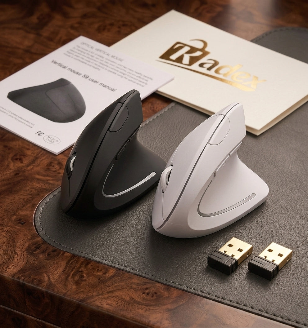 Two ergonomic wireless mice, one black and one white, displayed on a dark gray leather pad over a wooden desk, with a Radex card, user manual, and two USB receiver dongles.