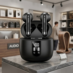 A detailed close-up shot of open matte black true wireless earbuds in their matching charging case. The earbuds feature silver tips and precision-textured stems, and the case displays a white LED battery level of "100" with L/R battery bars. They are displayed on a natural marble surface next to a smooth walnut block in a professional, well-lit retail environment.