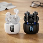 A side-by-side product shot of premium white and black wireless earbuds resting in their respective open charging cases, which show a digital battery life display, set against a softly blurred, warm oak desk background.